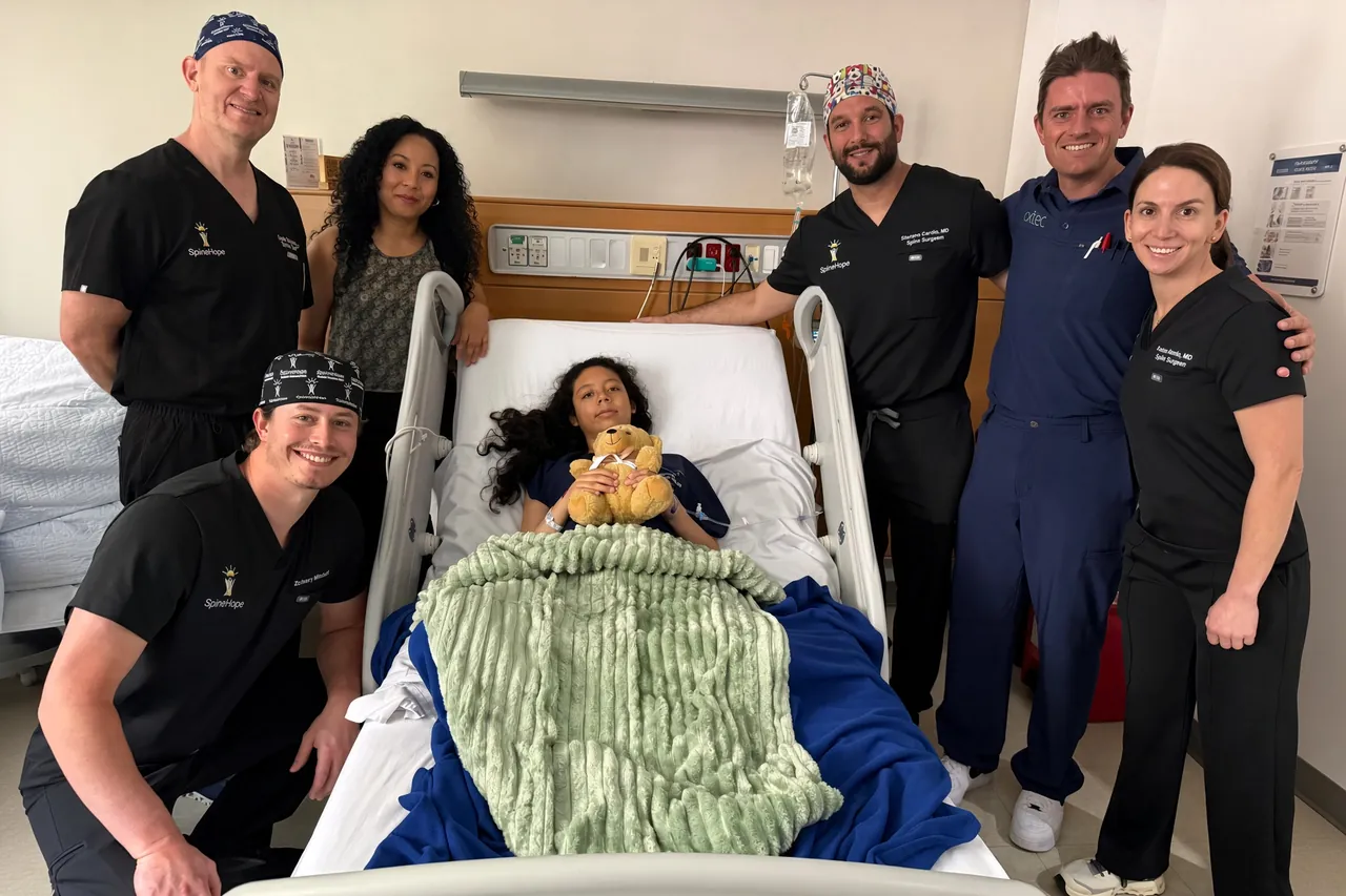 The SpineHope surgical team around a young patient in a hospital bed